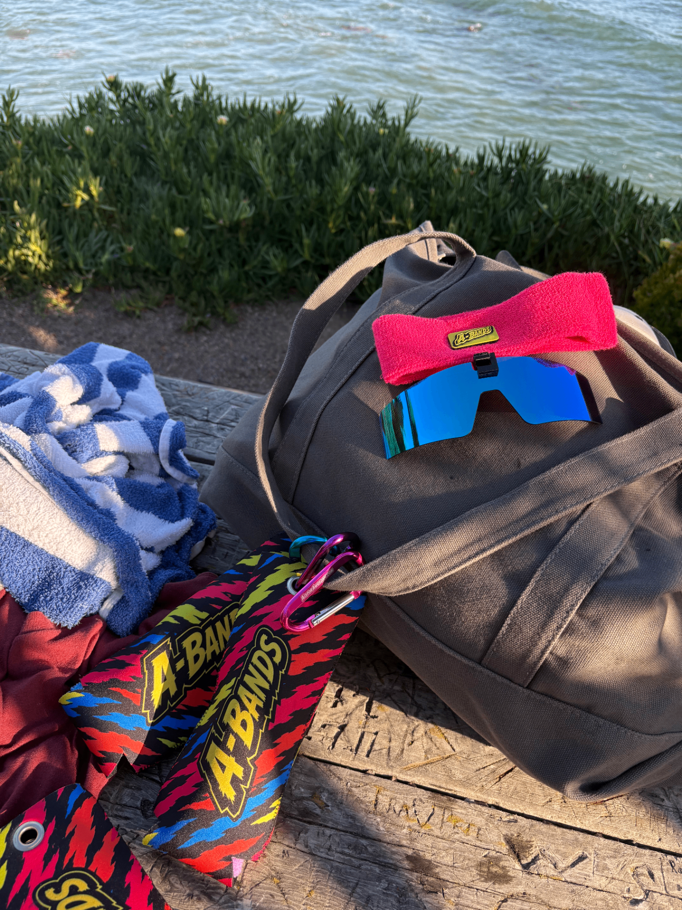 A-BANDS sunglasses and koozie case clipped to a canvas beach bag